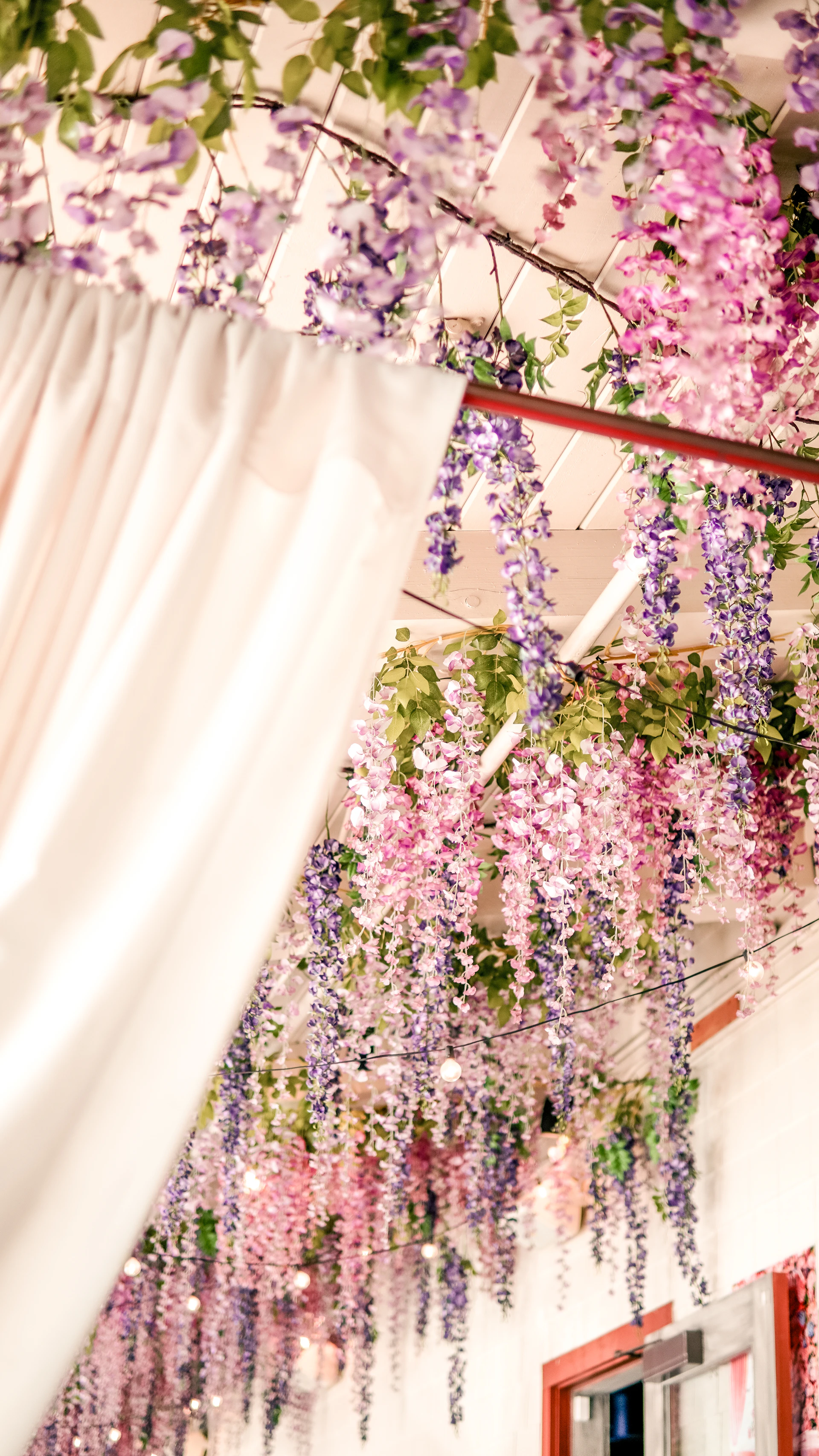 An elegant backdrop featuring cascading greenery and soft lavender blooms, perfect for a cozy bridal shower.