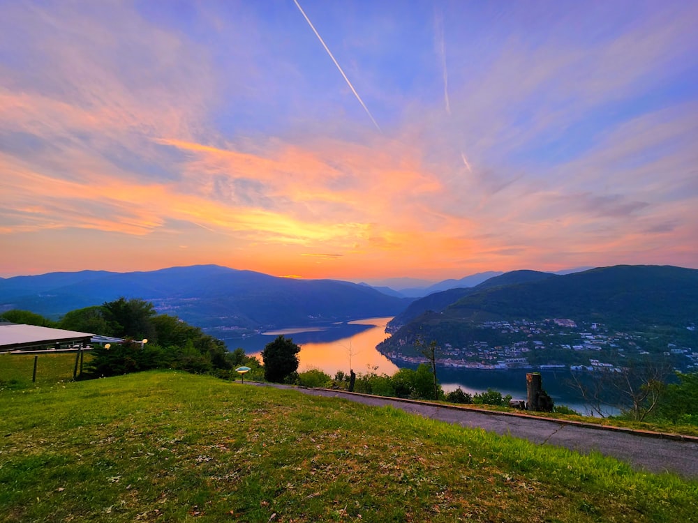 a scenic view of a lake and mountains at sunset