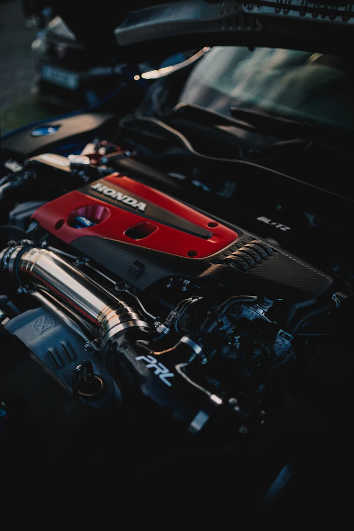 Detailed engine bay with a red engine cover under an open hood.