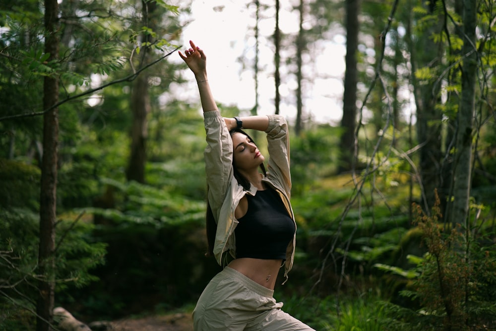 a woman standing in the middle of a forest