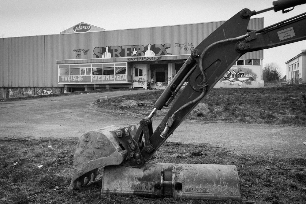 a black and white photo of a bulldozer in front of a building