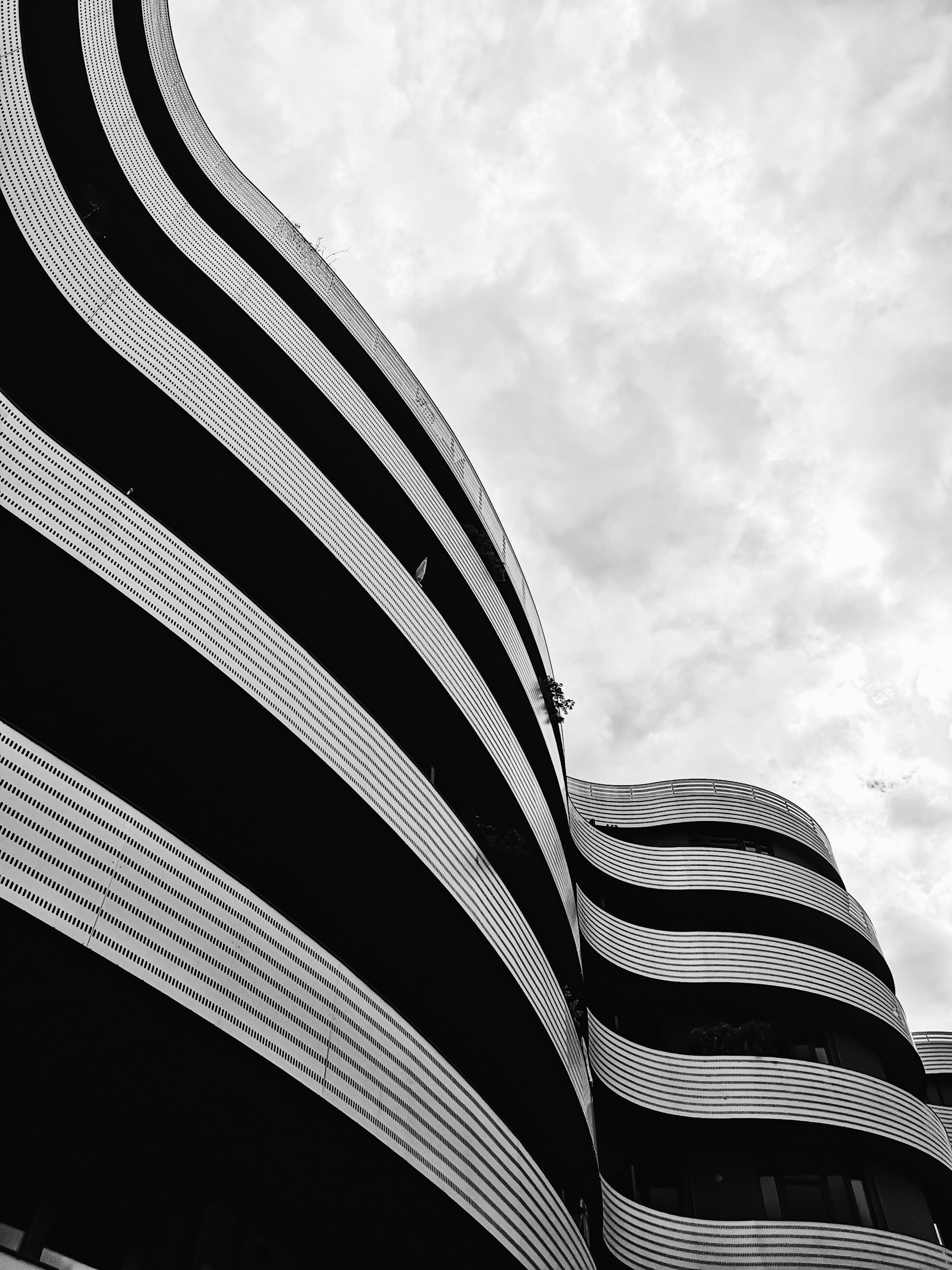 a black and white photo of a curved building