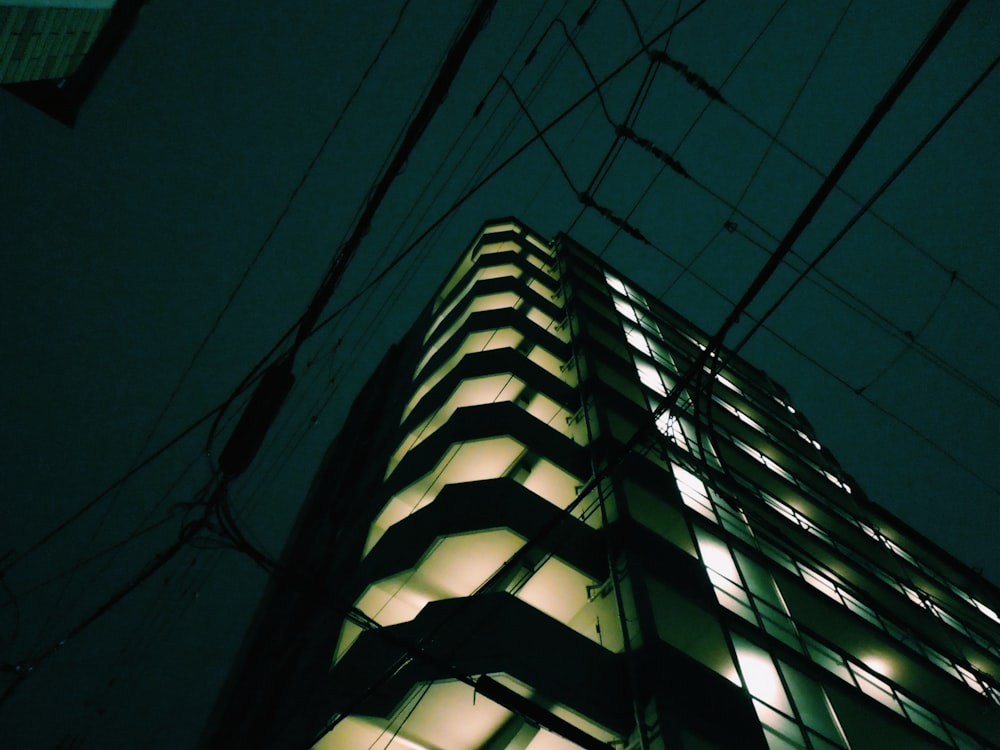 a tall building lit up at night in the dark