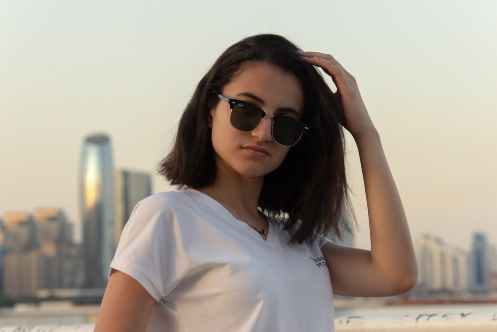 Una mujer con camisa blanca y gafas de sol negras