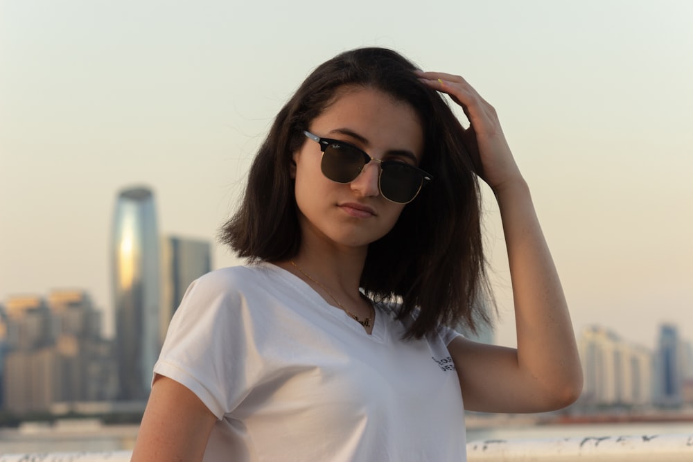 a woman in a white shirt and black sunglasses
