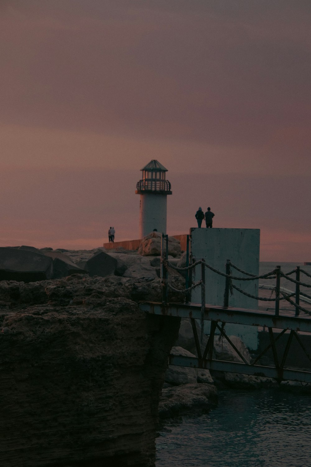 a lighthouse sitting on top of a cliff next to the ocean