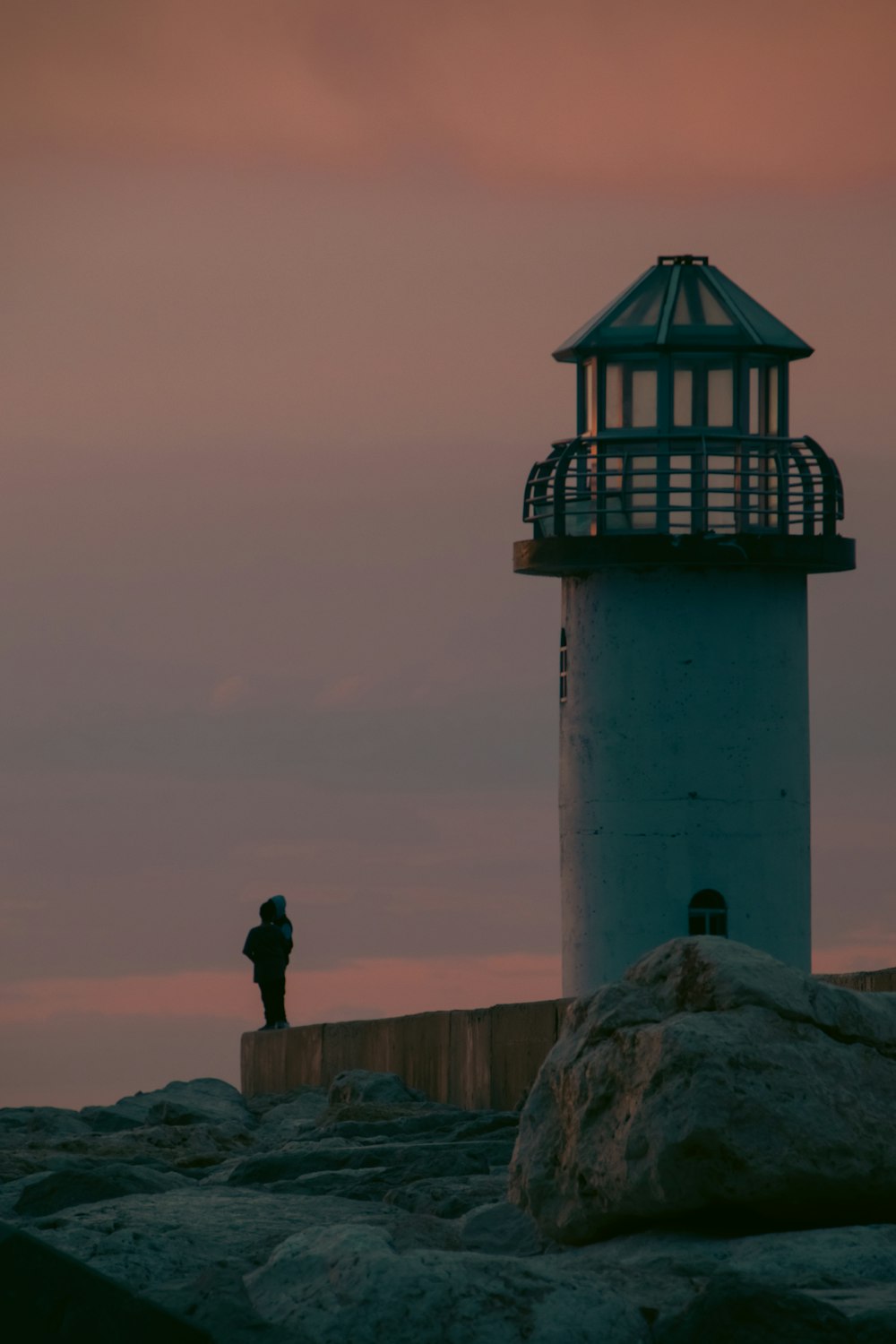 a person standing next to a light house