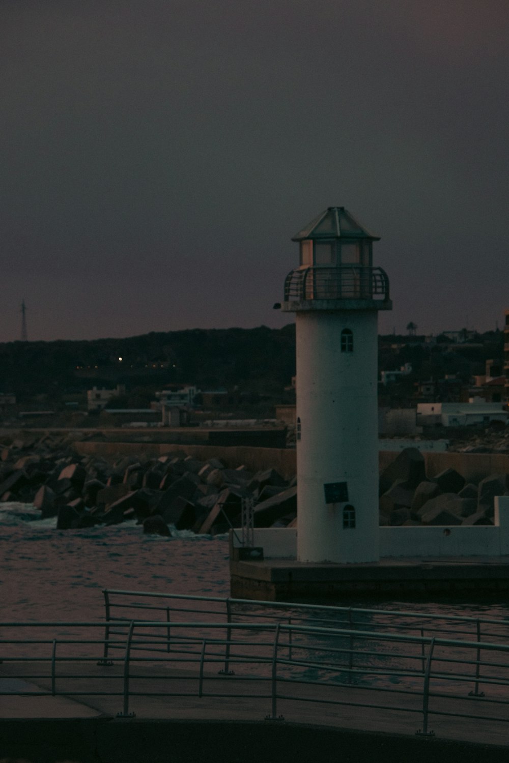 a light house sitting on top of a pier next to a body of water