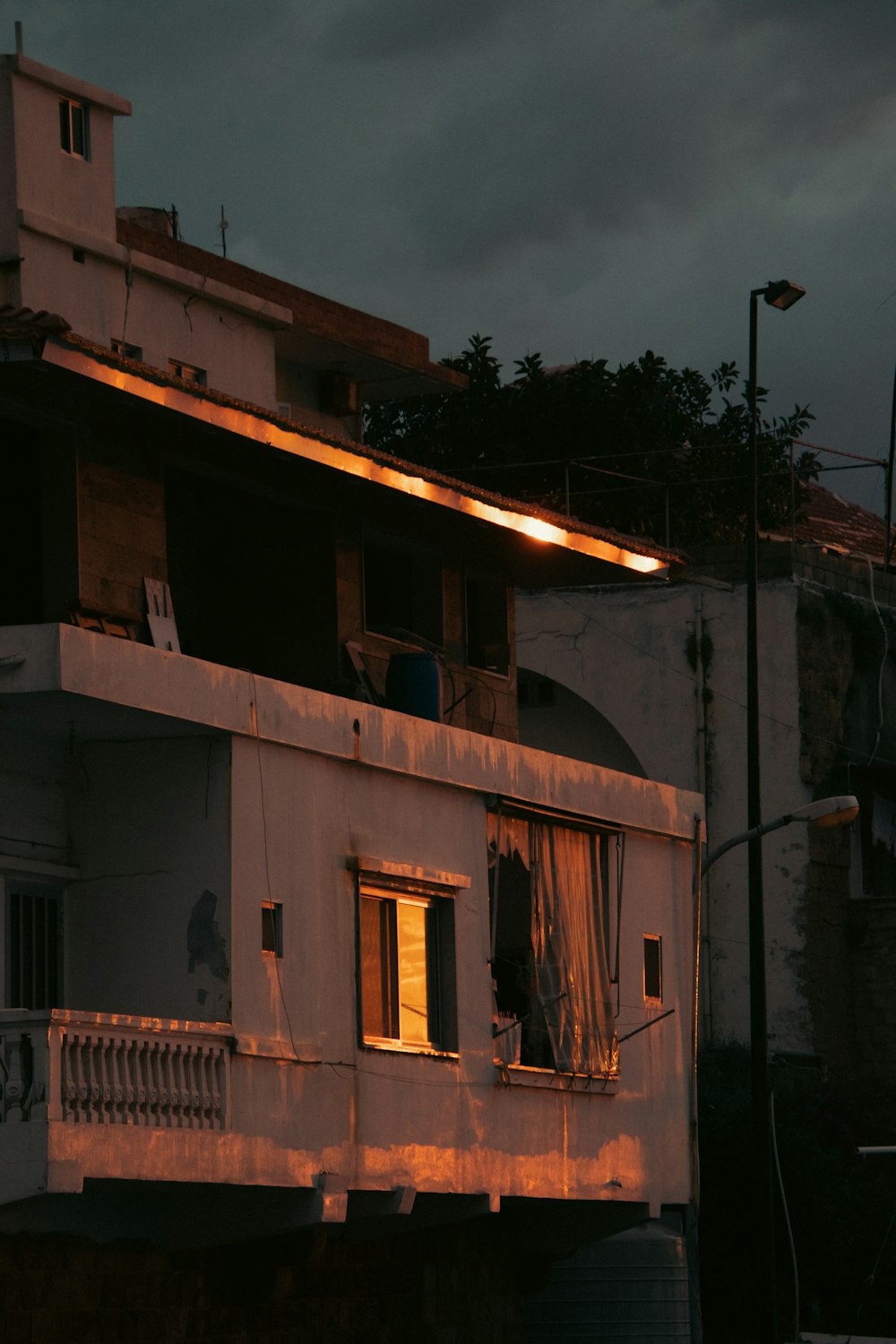 a white building with a balcony and a light on