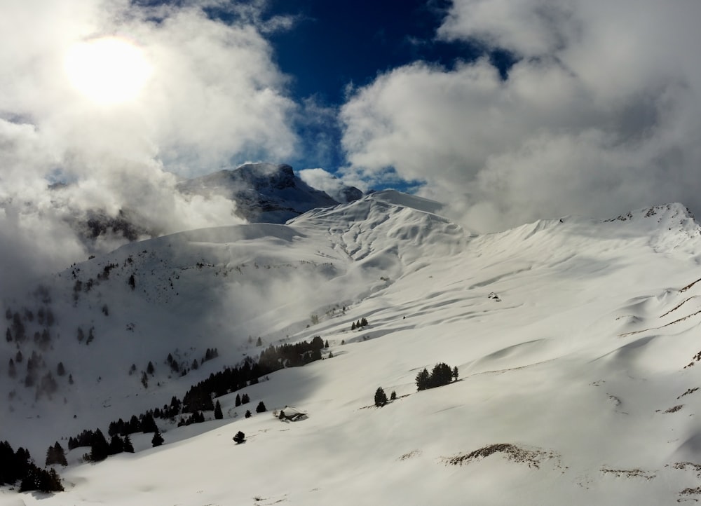 a mountain covered in snow under a cloudy sky