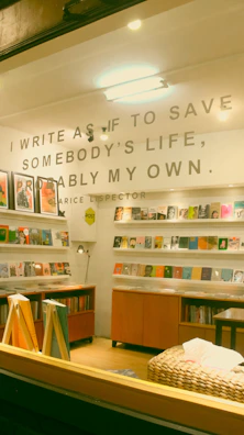 Susan Billings Mitchell writing at her cozy desk surrounded by stacks of well-loved books.