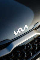 Close-up of a shiny car grille with the Korvex Auto logo subtly reflected.