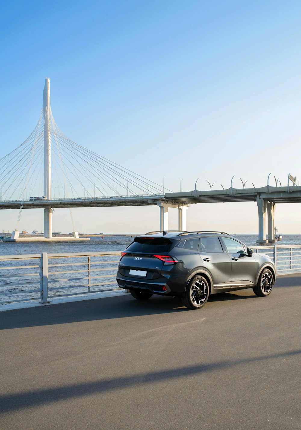 a car parked on the side of the road near a bridge