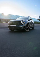 A sleek Hyundai Creta parked in front of a modern dealership building at sunset.