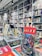 A bookstore interior filled with shelves of books arranged neatly. Several colorful books are displayed prominently on a table in the foreground, with one particular book featuring a vibrant and graphic cover standing upright.