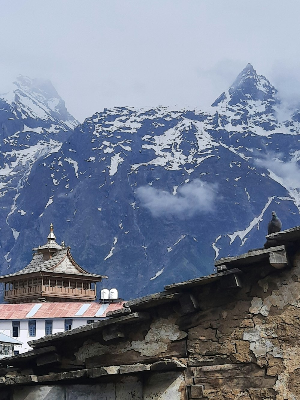 a view of a mountain range with a clock tower in the foreground