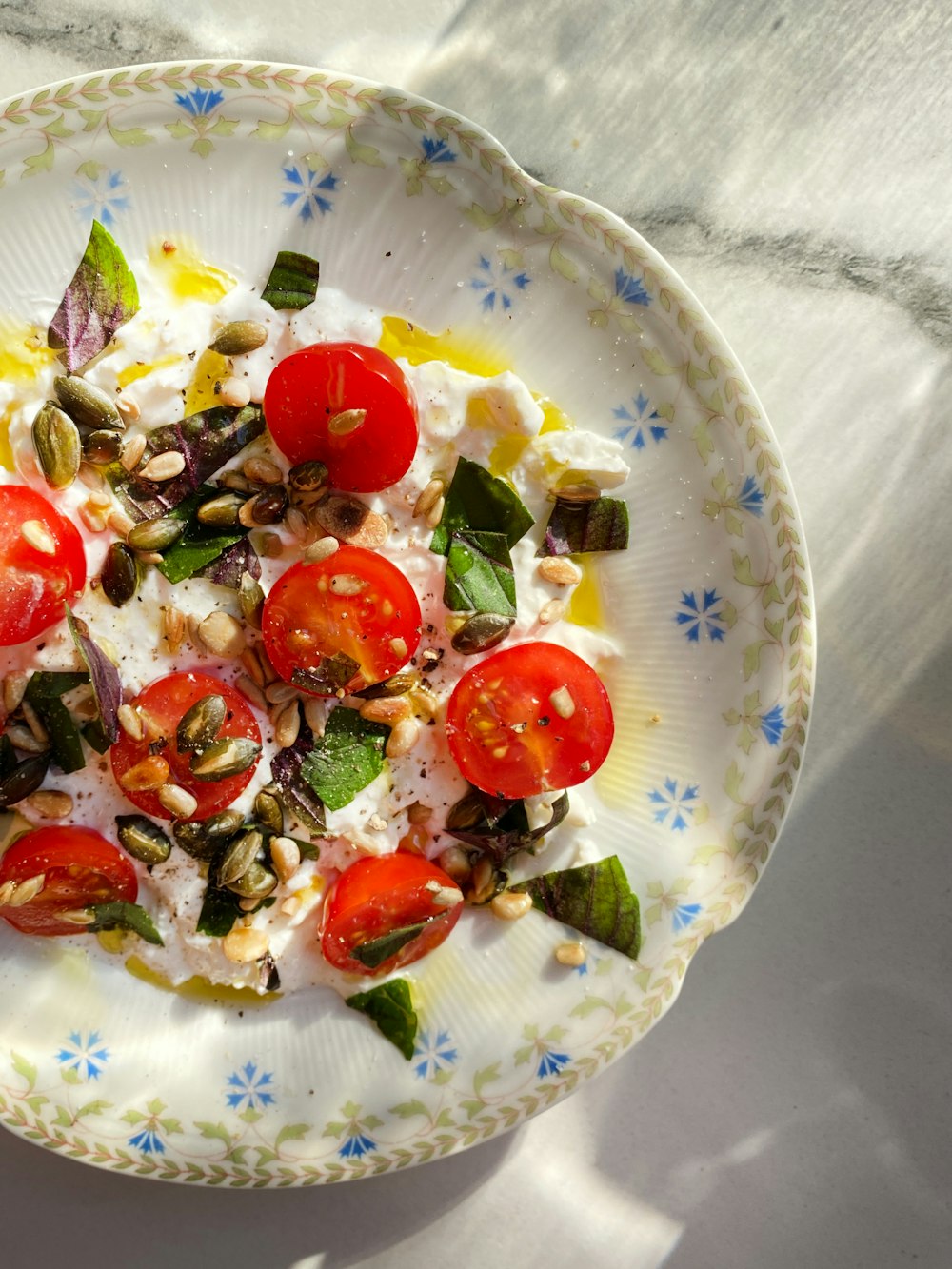 a white plate topped with a salad of tomatoes and spinach