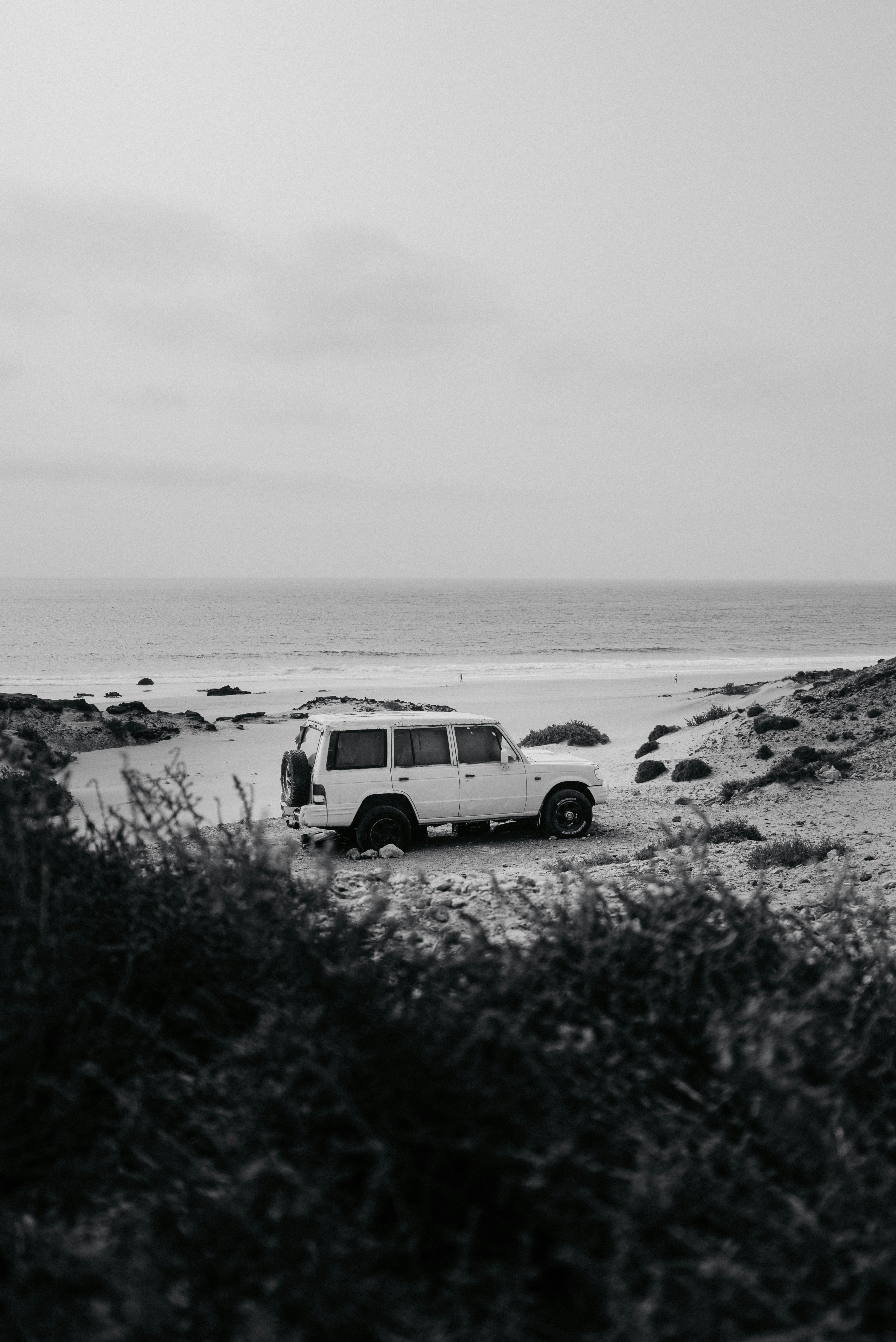 Une camionnette est garée sur la plage près de l’eau