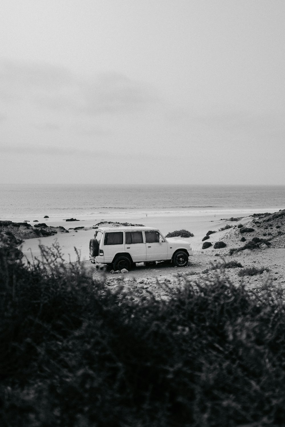a van is parked on the beach near the water