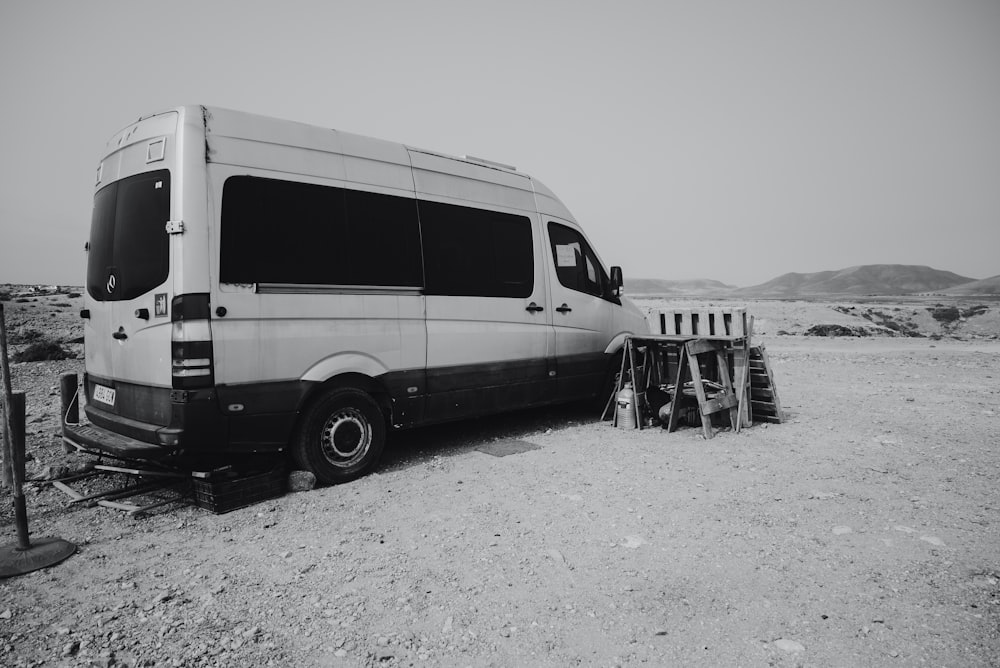 a black and white photo of a van in the desert