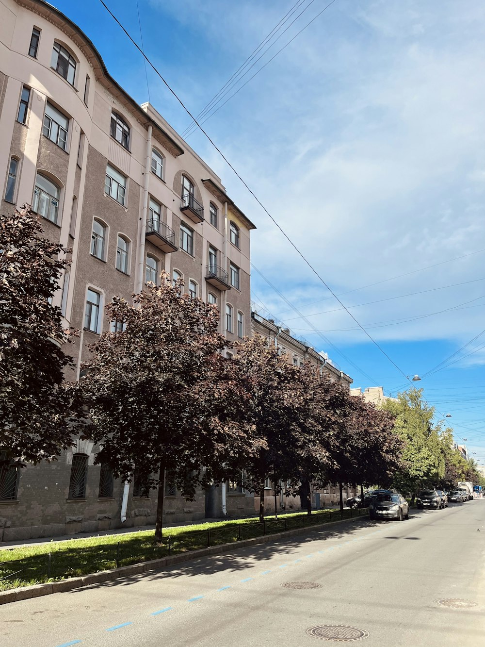 a city street lined with tall buildings under a blue sky