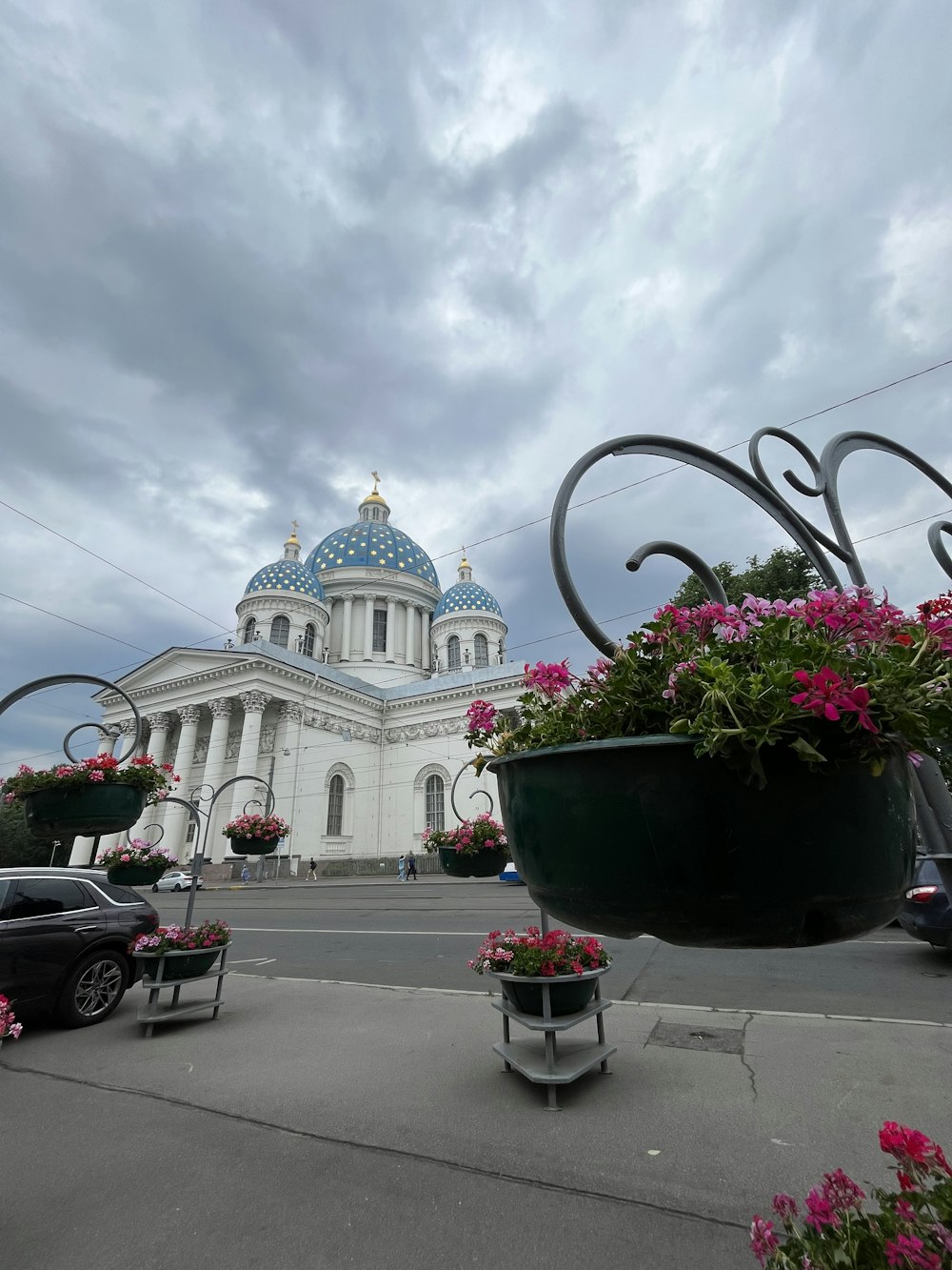 a large building with a dome and flowers in the foreground