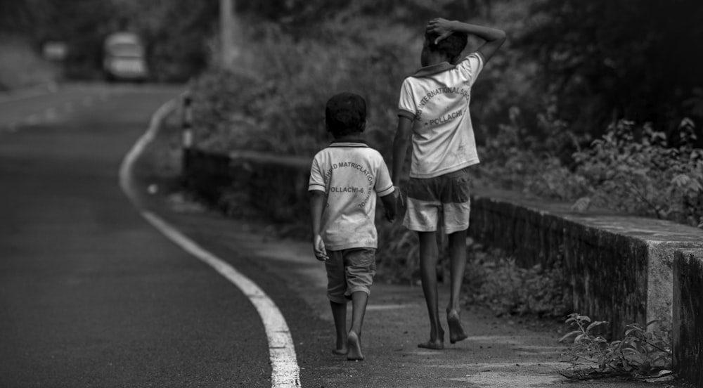 a man and a boy walking down a road