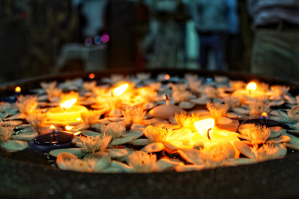 a bowl filled with water and lit candles