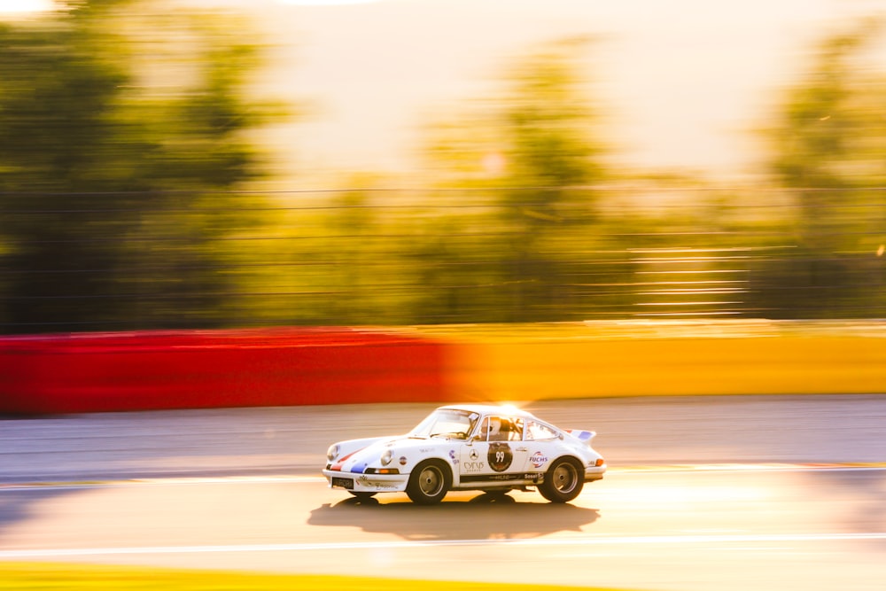 a car driving down a race track with trees in the background