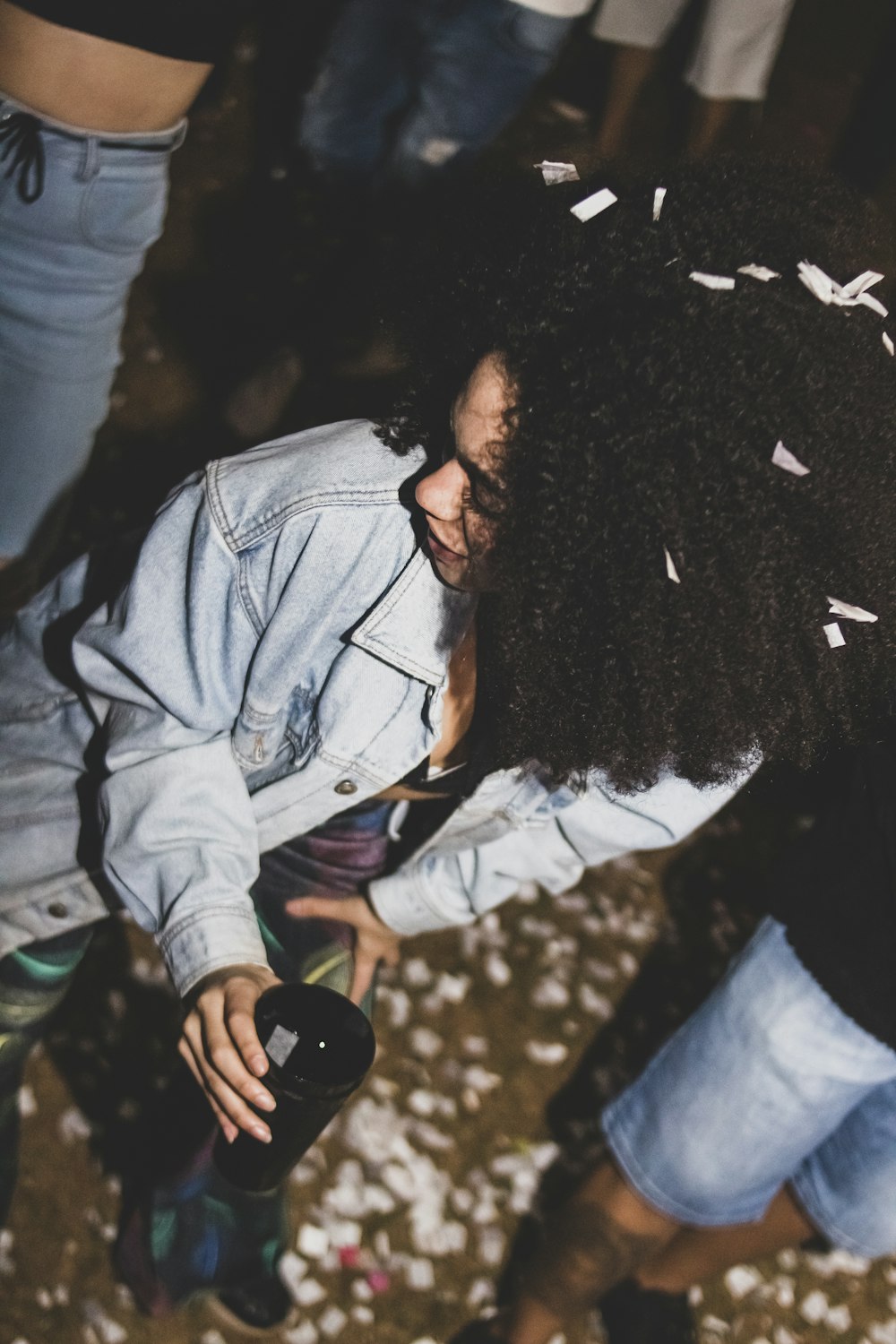a woman with an afro is holding a bottle of wine