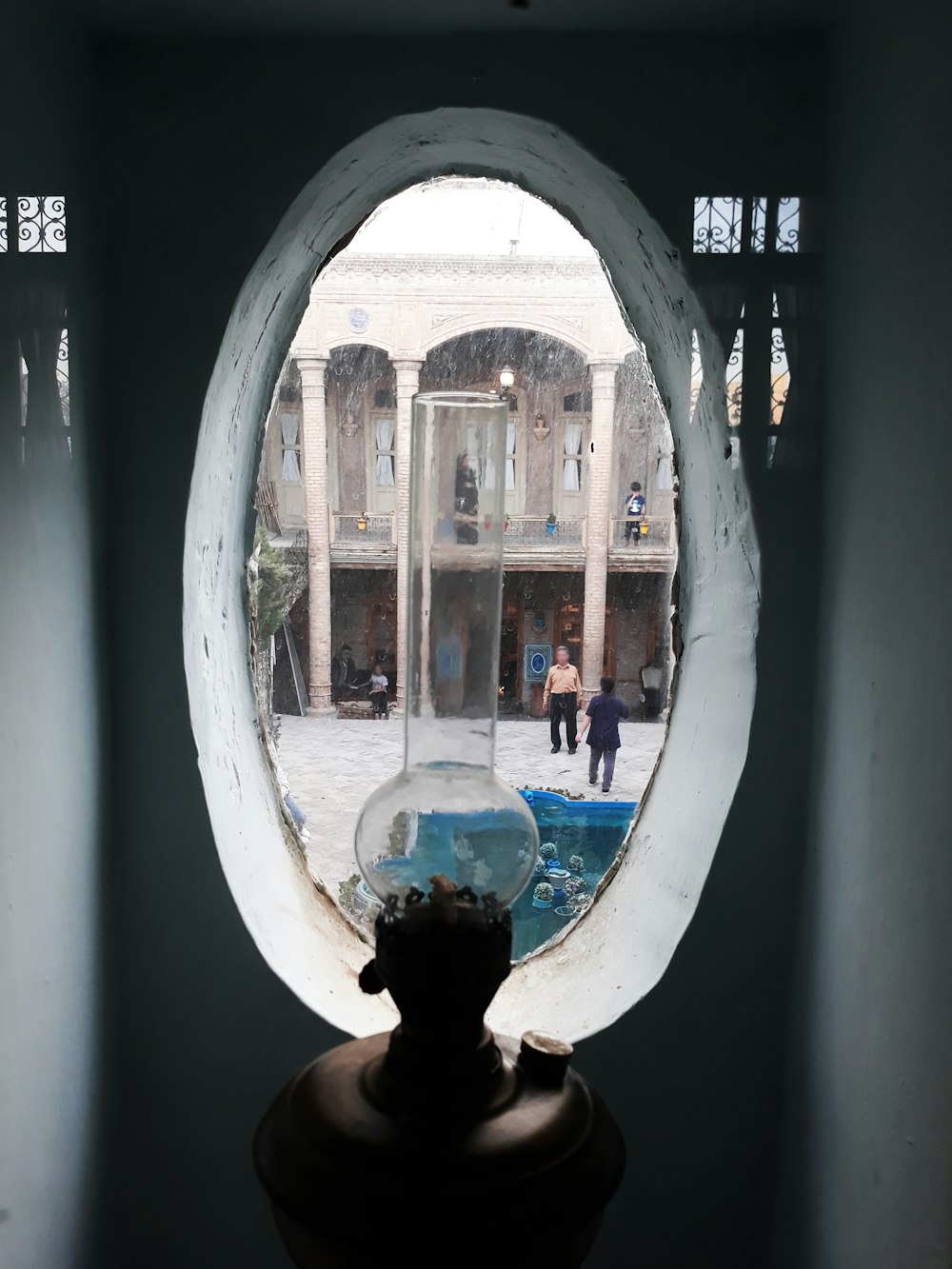 a round window with a reflection of two people in it