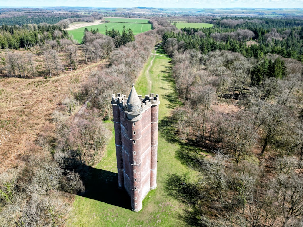 an aerial view of a tower in the middle of a field