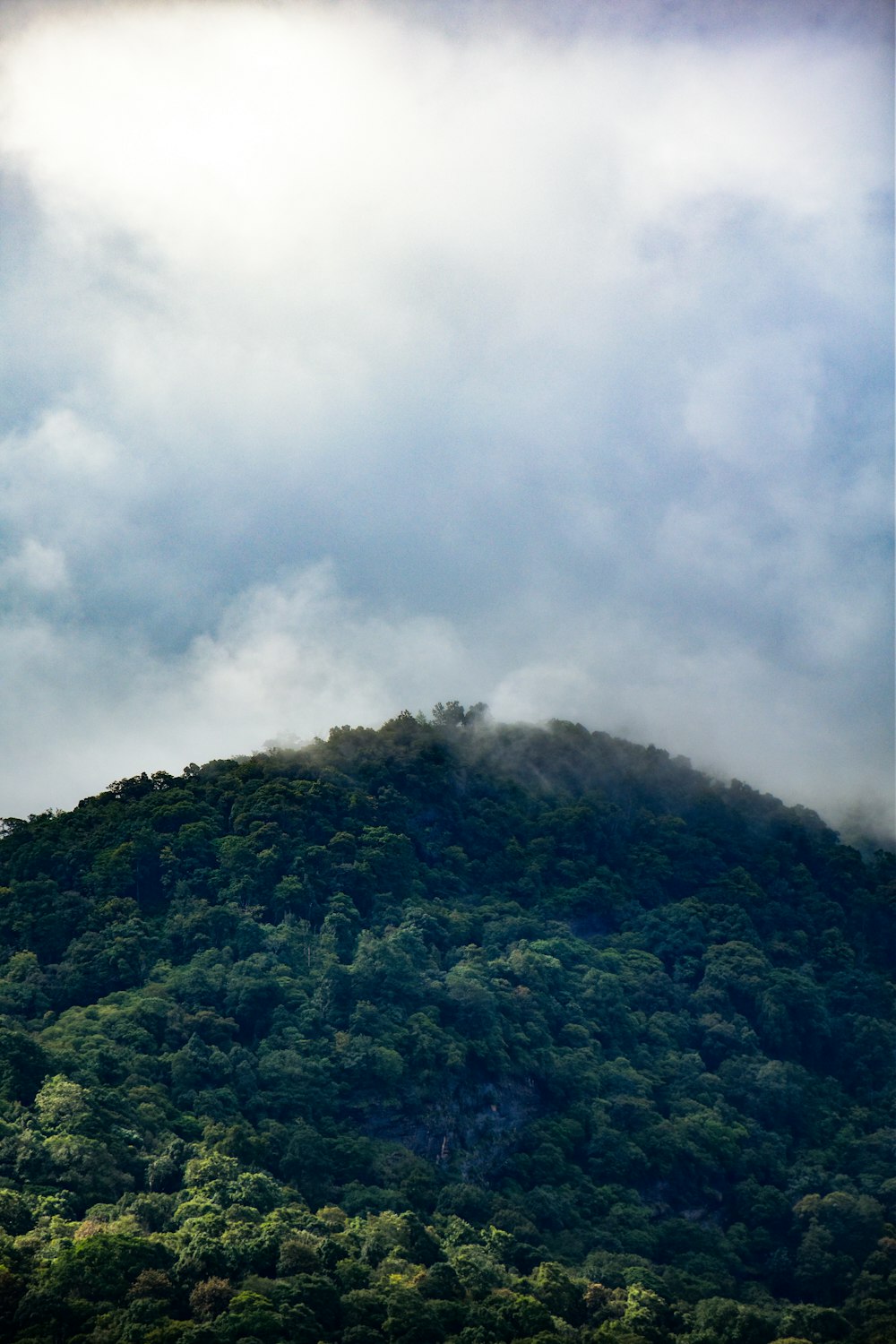 a very tall mountain covered in lots of clouds