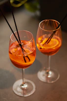 a couple of glasses filled with drinks on top of a table