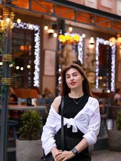 A young woman wearing a stack of minimalistic bracelets at a café.
