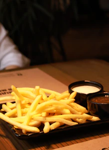 a plate of french fries with dipping sauce