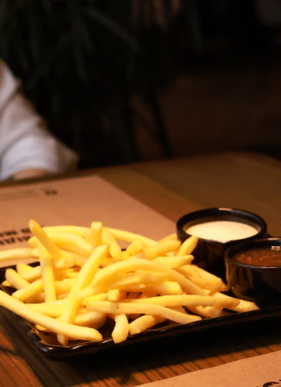 a plate of french fries with dipping sauce