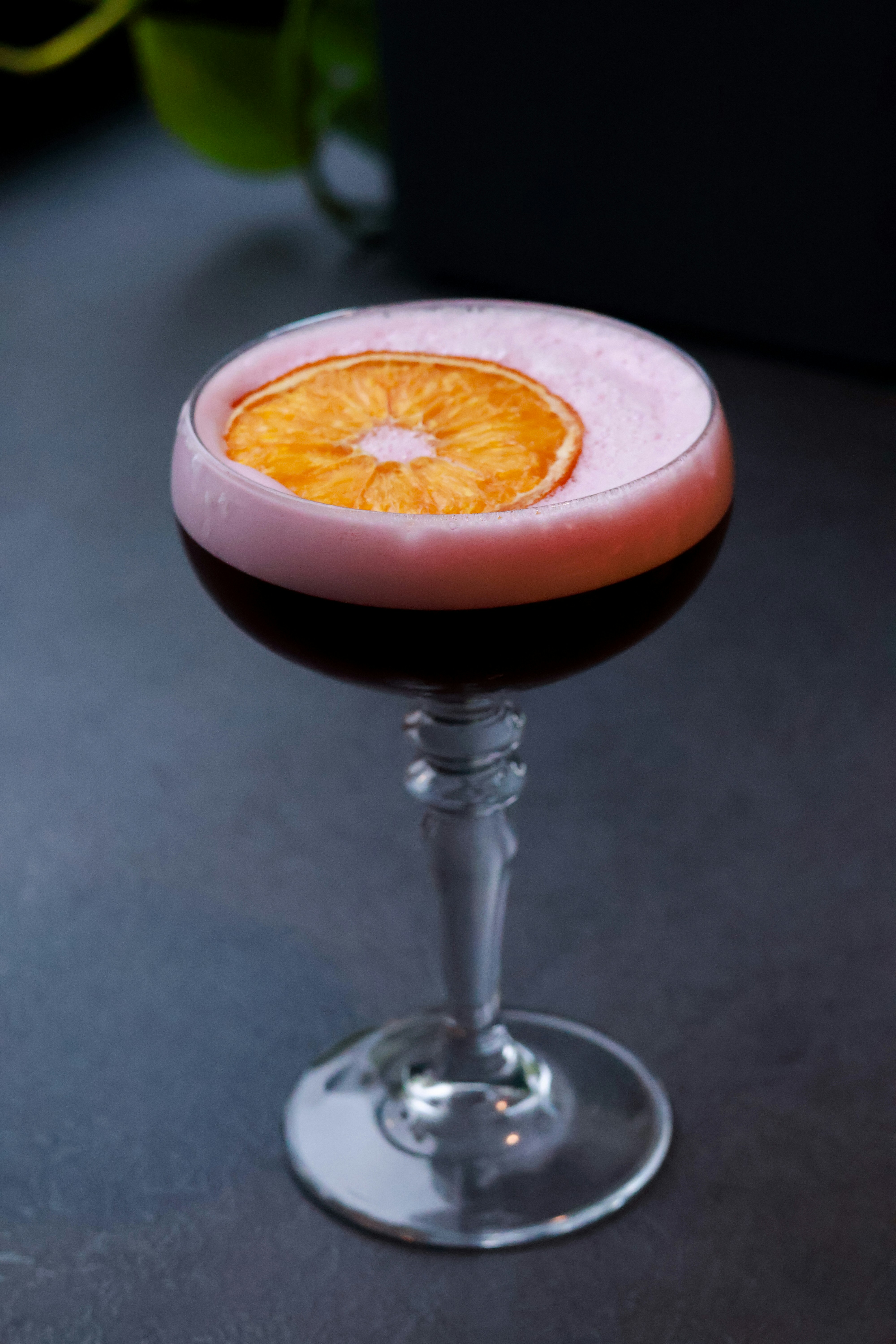 Amaretto Sour cocktail with foam top and cherry garnish in a coupe glass