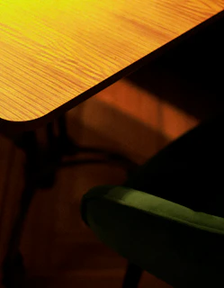 A cozy furniture store corner with wooden chairs and a small table bathed in warm light.