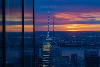 Modern luxury home with a stunning city view at sunset.