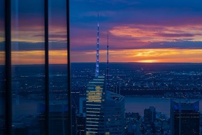 Modern luxury home with a stunning city view at sunset.