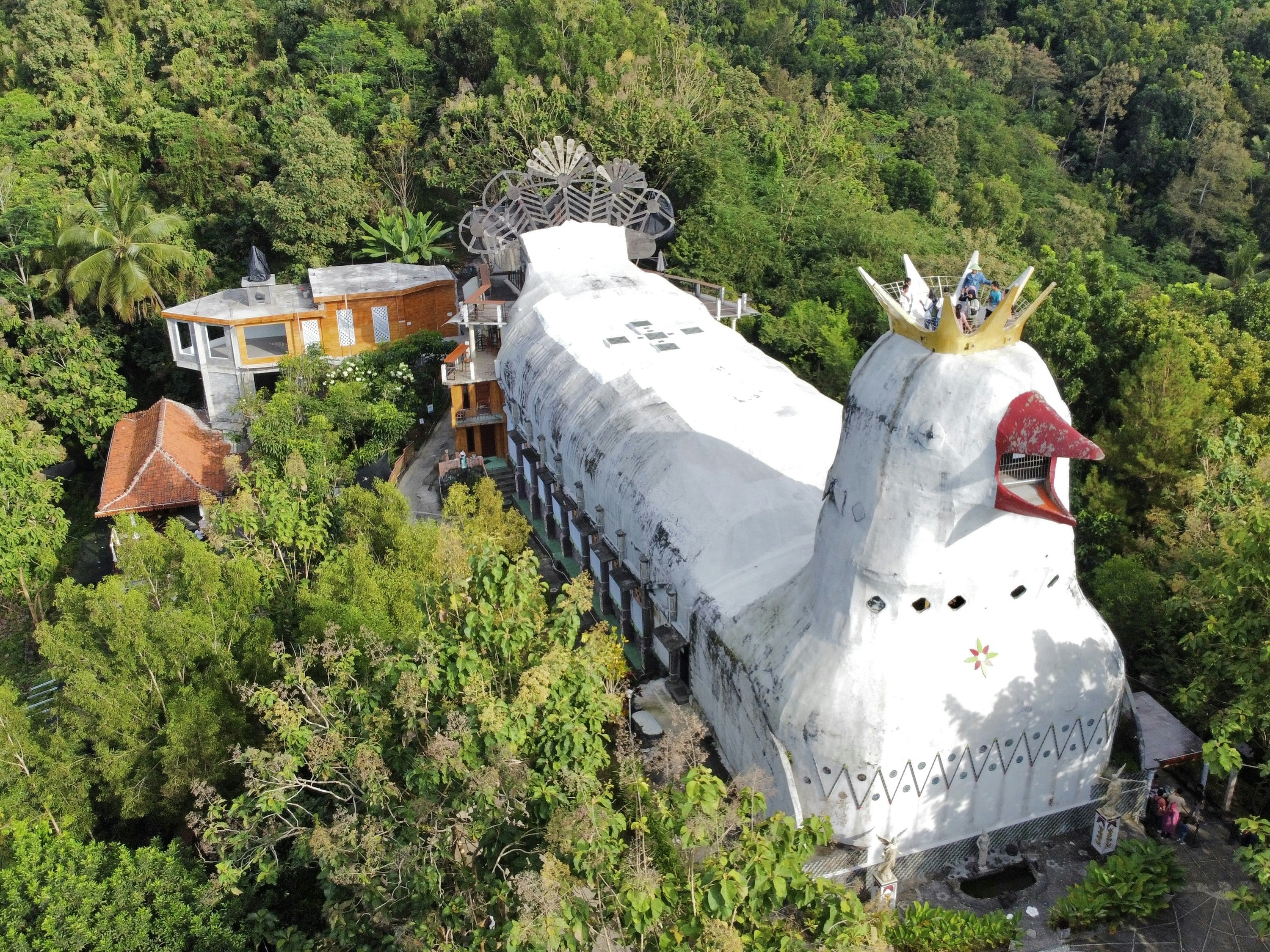 a large white bird shaped building in the middle of a forest