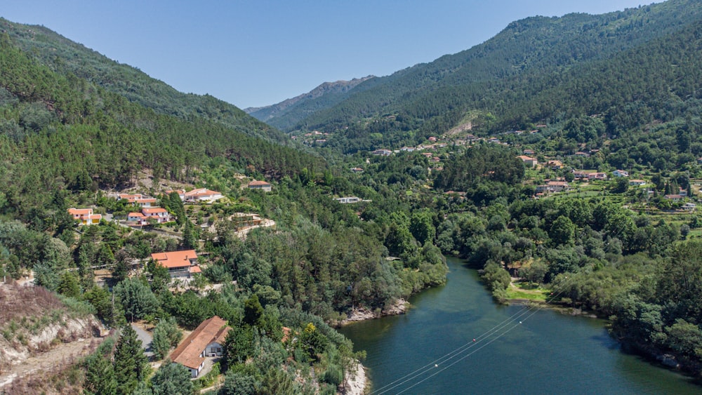 a river running through a lush green forest covered hillside