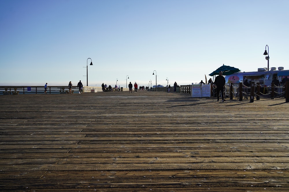 a group of people standing on top of a wooden pier