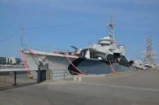 a large gray boat docked at a pier