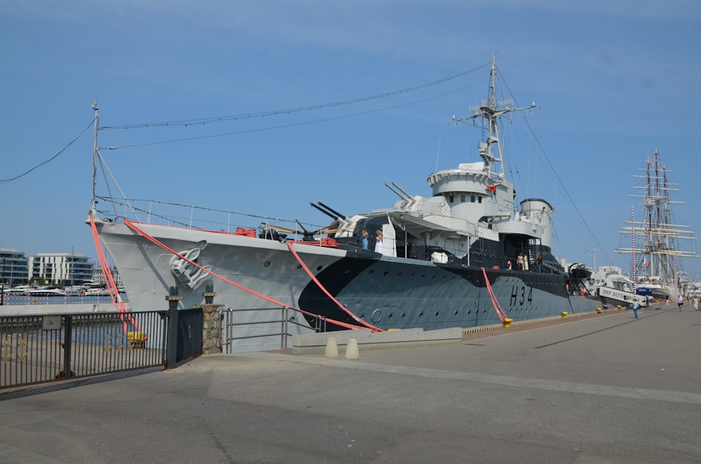 a large gray boat docked at a pier