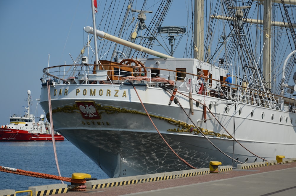 a large white boat docked at a pier