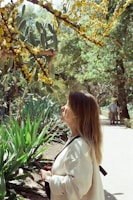 a woman standing in front of a tree with yellow flowers