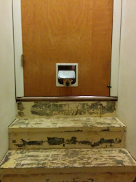 A cozy indoor scene showing a medium-sized dog door in black, with a small terrier happily passing through.
