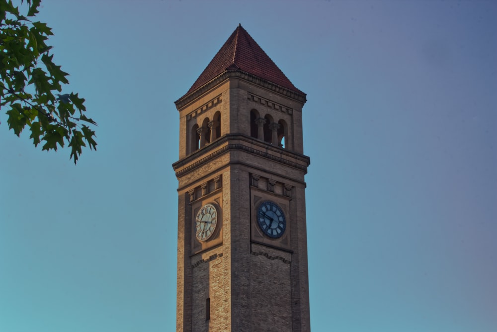 ein hoher Glockenturm mit einer Uhr auf jeder Seite